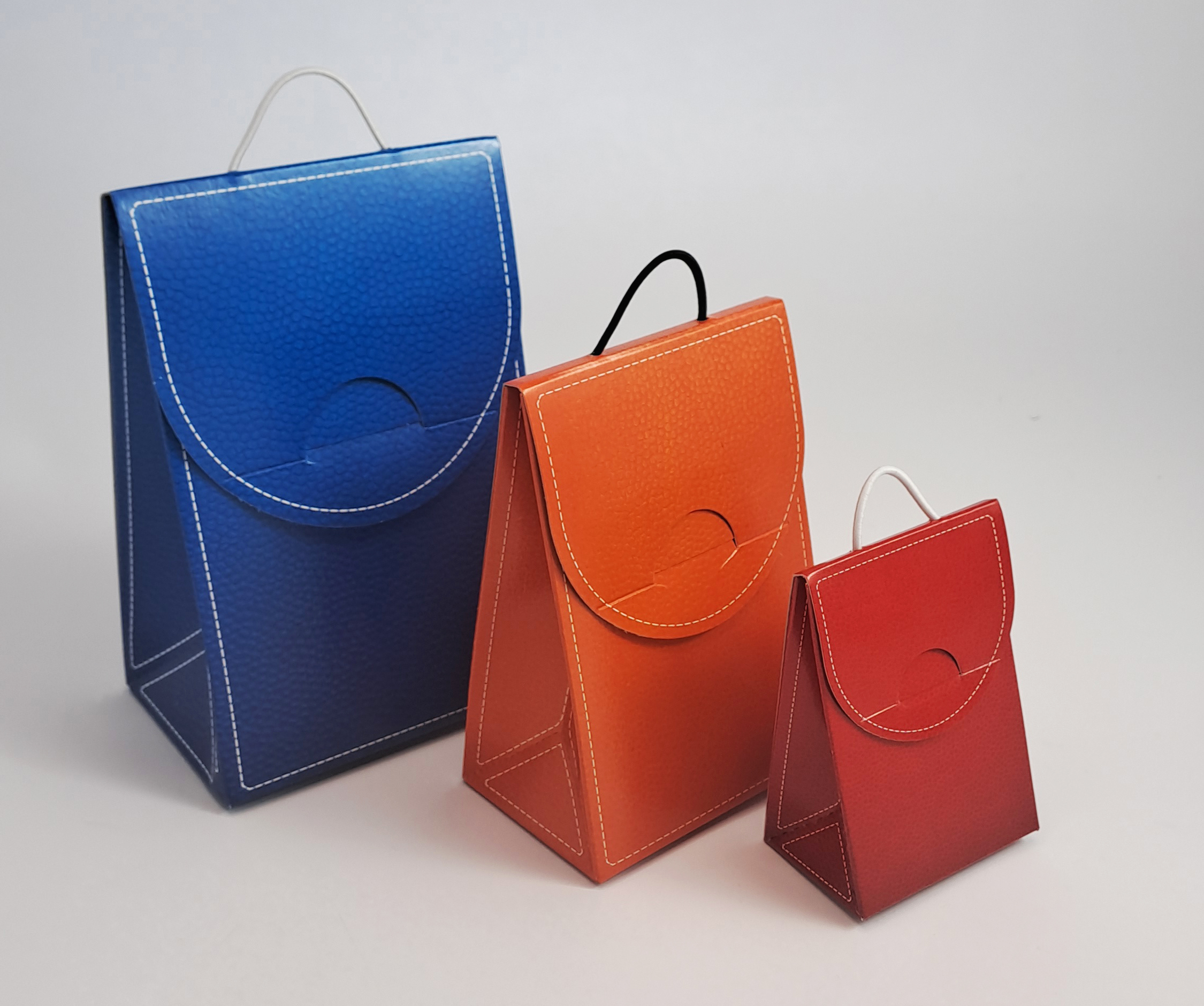 Handtaschen aus Recycling-Karton in drei verschiedenen Größen.