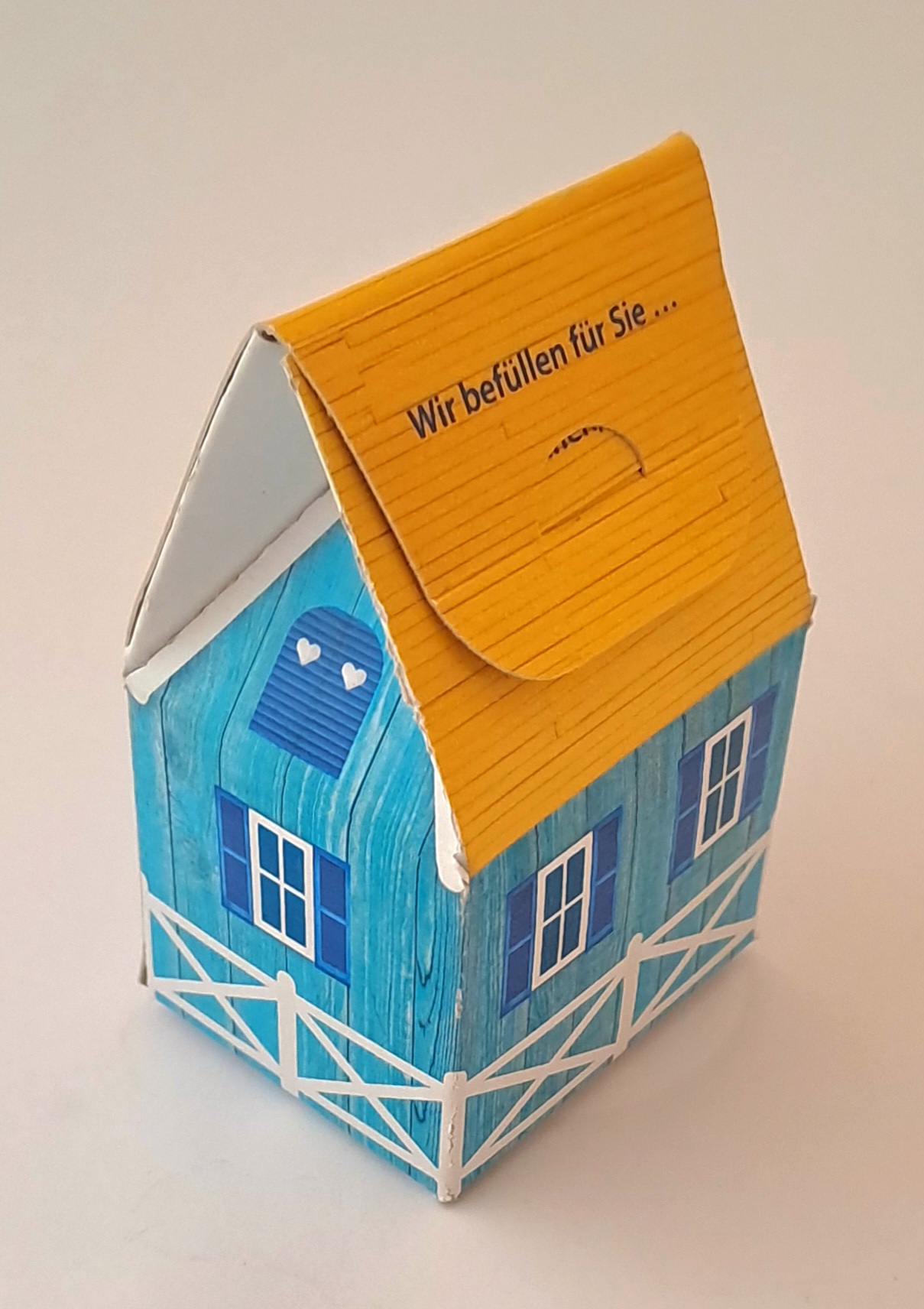 Kleines Haus aus Karton als Geschenkverpackung.