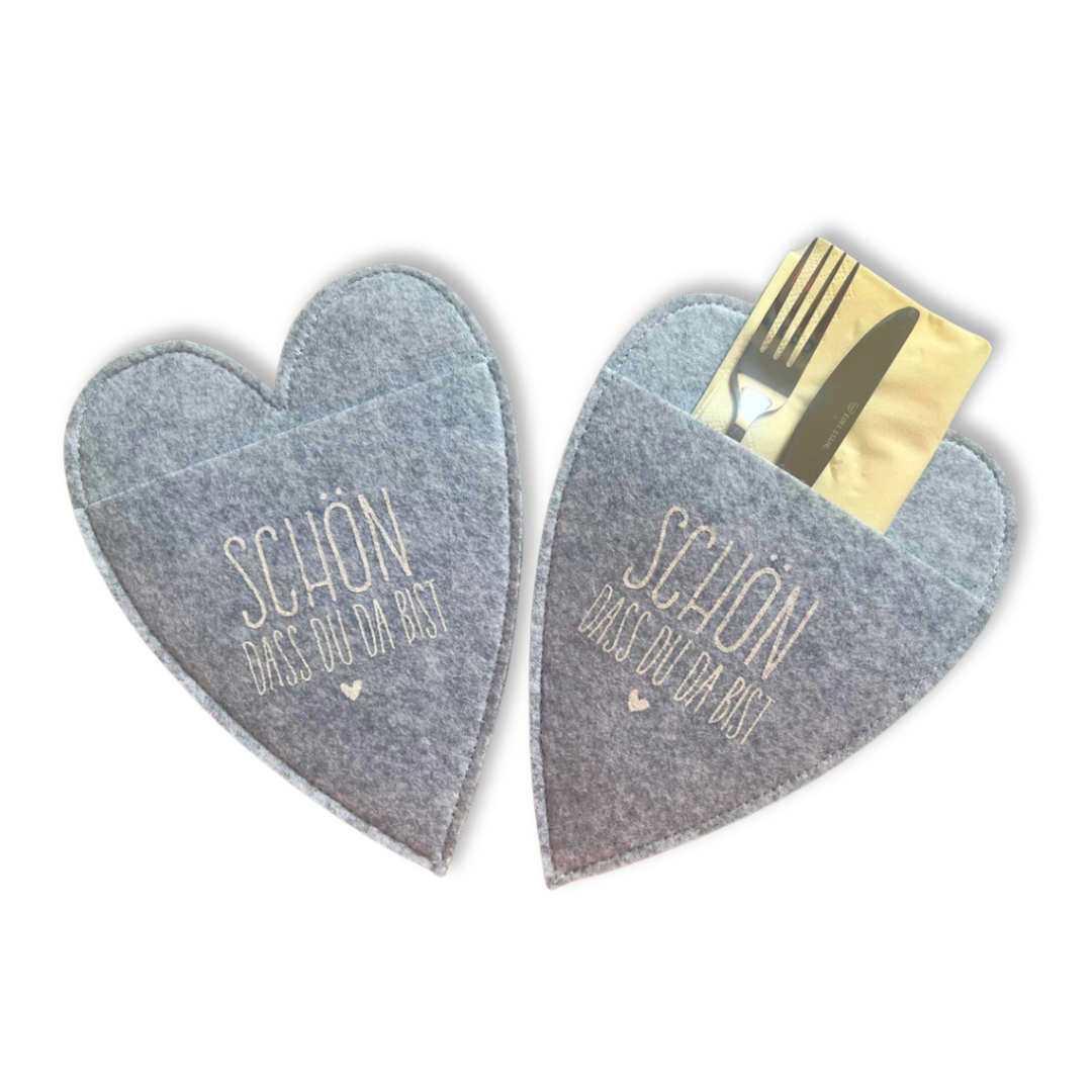 Zwei graue Bestecktaschen aus Wollfilz in Herzform mit Werbeaufdruck.