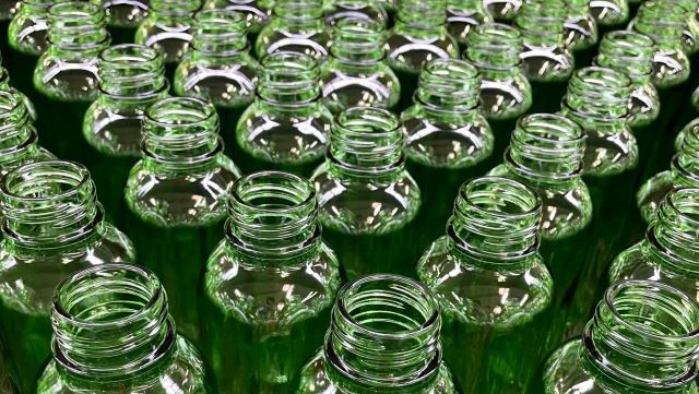Viele grüne Glasflaschen mit offenem Schraubverschluss