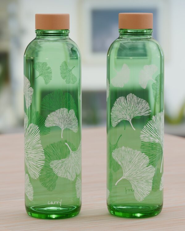 Zwei grüne Glasflaschen mit weißem Aufdruck Ginkgoblättern