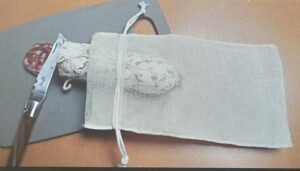 PLA Lebensverpackung mit Salami, Küchenmesser auf Schneidbrett