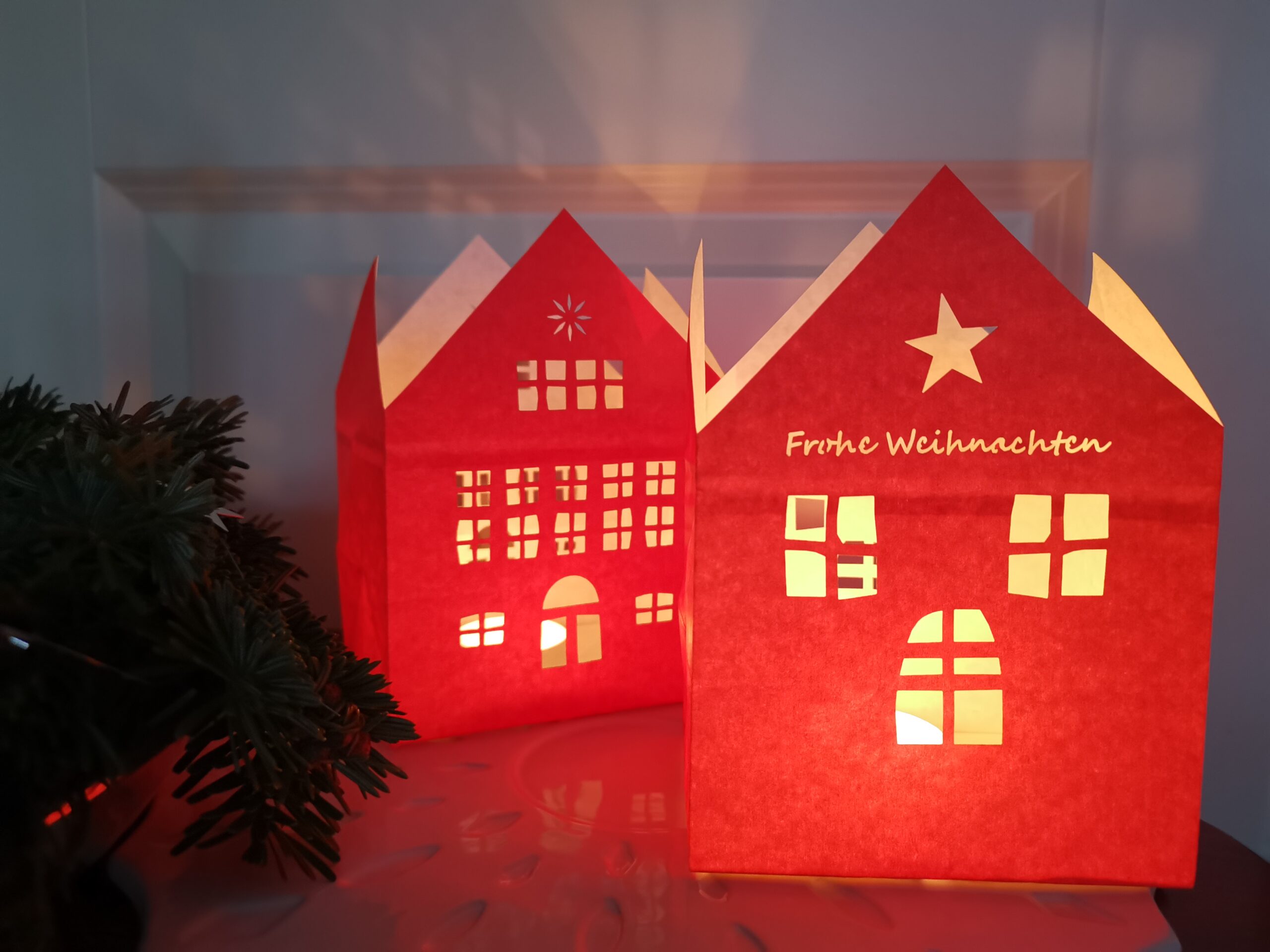 Windlichter in Rot als Haus